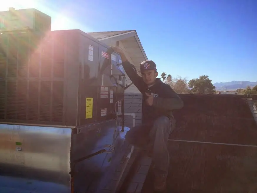 HVAC technician performing Boiler Repair on a rooftop unit in Elkins